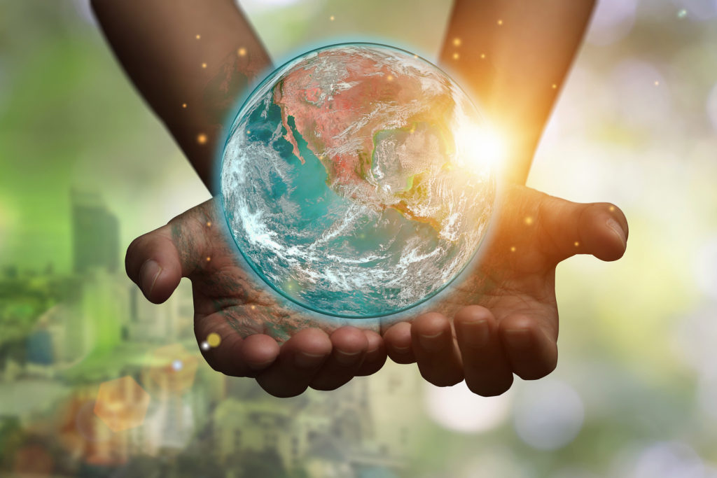 Hands holding blue earth globe over and blurred city background for online therapy in florida, and counseling in St. Petersburg, FL with a skilled st. petersburg therapist.