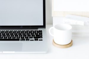 Laptop with cup of coffee next to it on a white table. You can get Online Couples Counseling in St. Petersburg, FL with a St. Pete therapist who specializes in marriage counseling and couples therapy with online therapy in Florida. Meet with a therapist in St. Petersburg, FL today! 33702