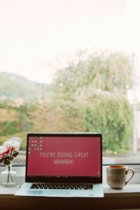 Laptop on table in window with a view. Screen says "You're doing great mamma!" to support maternal mental health in St. Petersburg, FL. Get help from a St. Pete therapist with an online therapist in Florida.