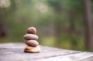 Stacked rocks on a table. Find balance in counseling with a St. Pete therapist here.