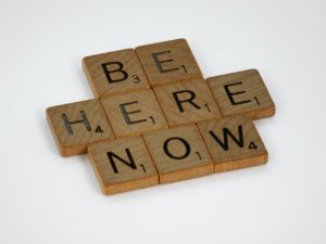 Scrabble letters spelling "Be Here Now". Representing a way of coping with a Panic Attack. You can get anxiety treatment and counseling in St. Petersburg, FL via online therapy in Florida with a St. Pete therapist here.