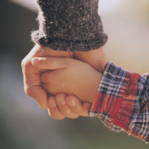 Child and adult holding hands. Getting connected with your inner child can take help with a St. Pete Therapist via online therapy in Florida here!