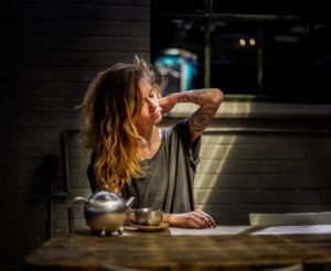 Woman stretching over a pot of tea at the table. Beat bedtime anxiety with healthy habits. Counseling in St. Petersburg, FL can help you cope via online therapy in Florida with a St. Pete therapist. 33701