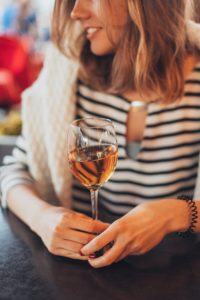 Wine Time: Woman holds glass of wine in her hand. Therapy in St. Petersburg, FL can help you cope with anxiety, depression, stress and overwhelm. Get started with online therapy in Florida with a St. Pete therapist here!