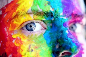 Face painted with rainbow zoomed in on eyes. PTSD treatment and trauma therapy in St. Pete counseling can be helpful for holistic mental health st petersburg fl here.