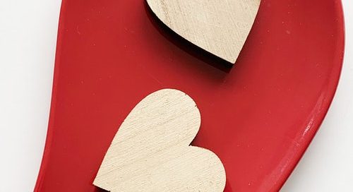 Two wooden hearts on a red background. How to know what you really want in relationships