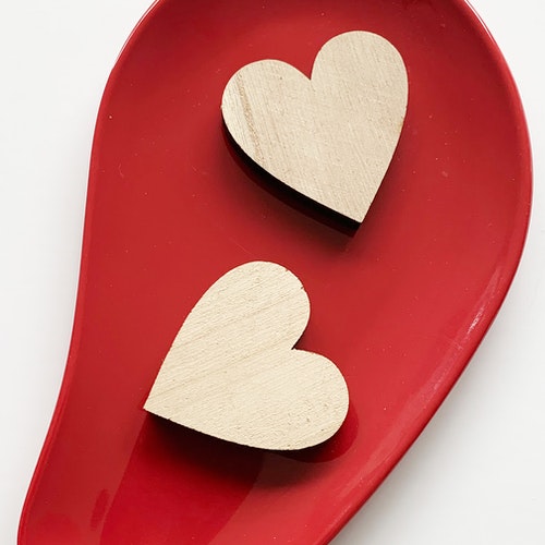 Two wooden hearts on a red background. How to know what you really want in relationships